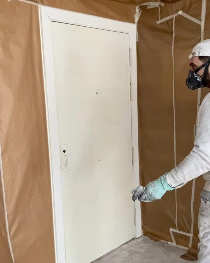 Profesional de MCG lacando una puerta con equipo de protección