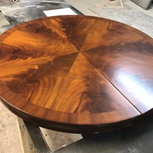 Mesa redonda de caoba barnizada a brillo en el taller